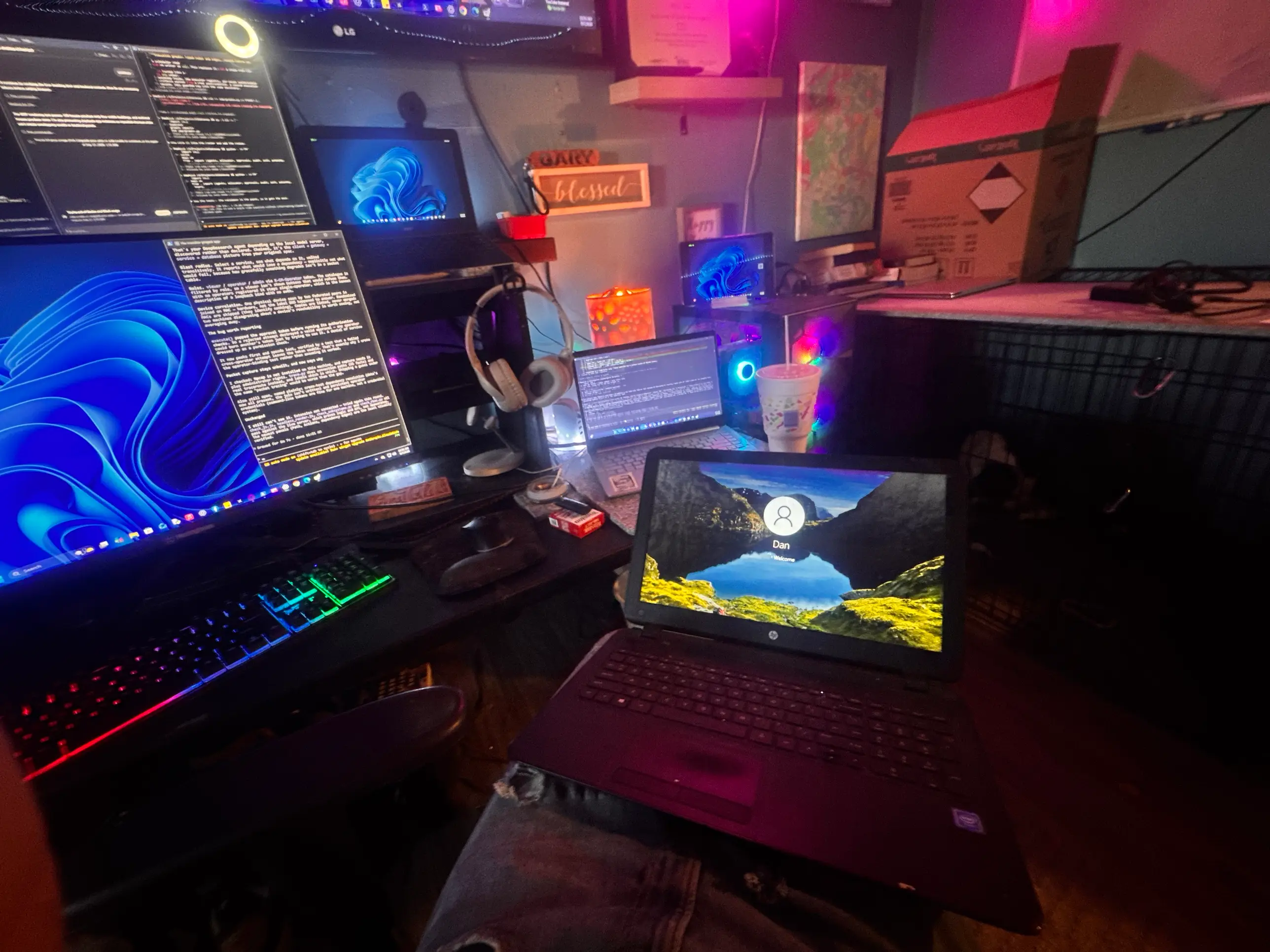 The real workbench: several laptops and monitors running diagnostics side by side, terminal output on screen, under coloured workshop lighting.